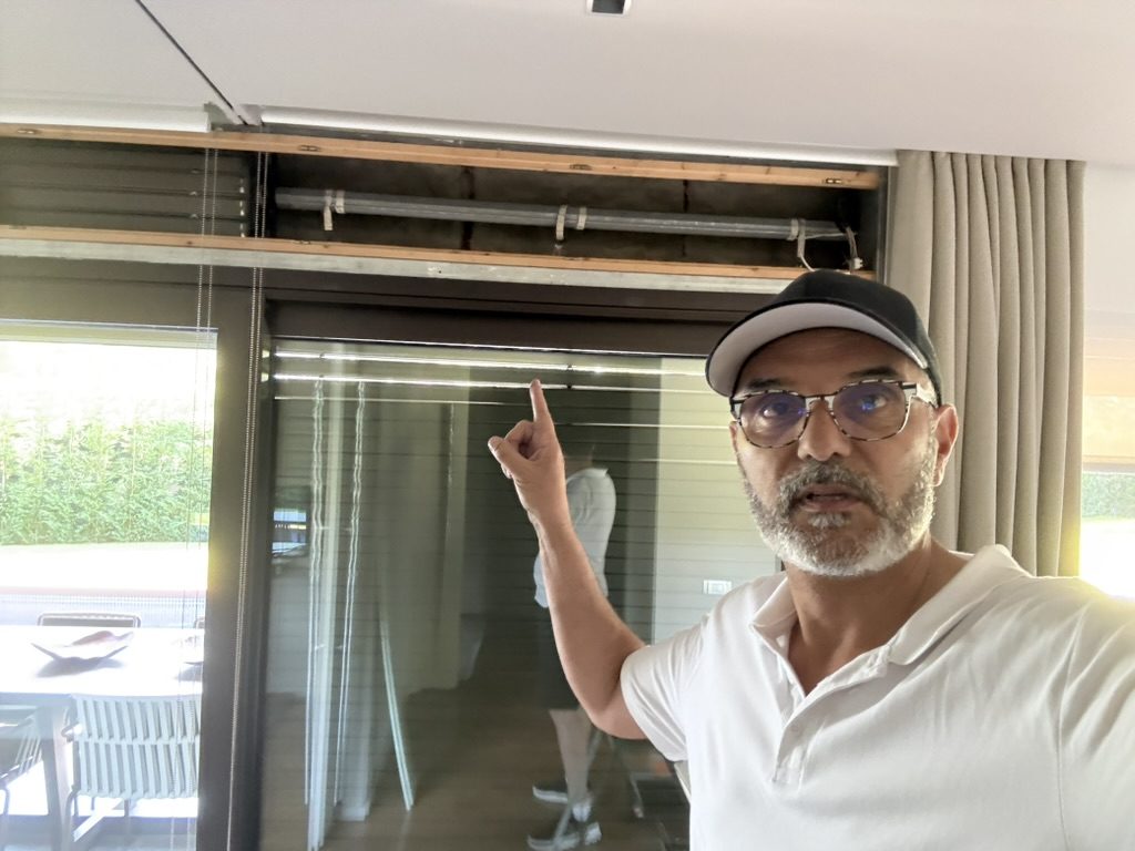Sergi señalando el cajón abierto de un cortinaje mientras explica la avería a un cliente