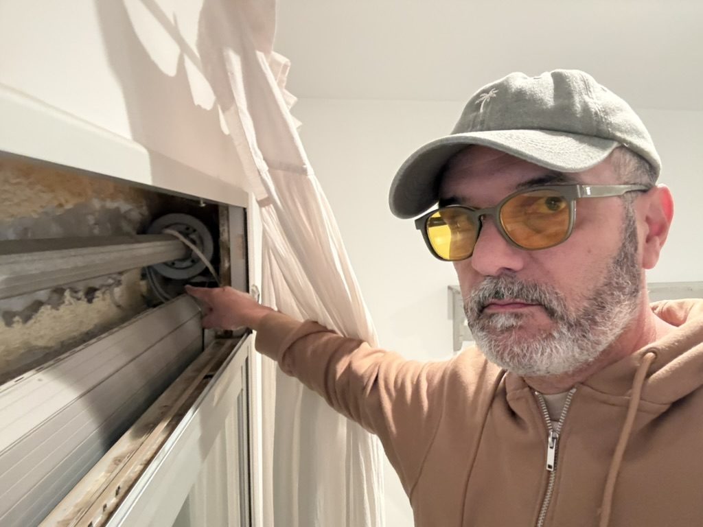 Sergi señalando el mecanismo del interior del cajón de una persiana desmontada